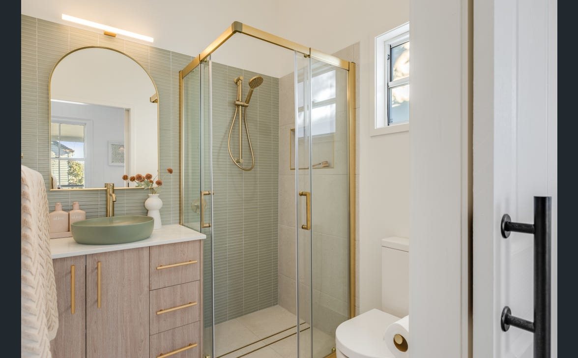 Ensuite with illuminated mirror lighting and brass fittings